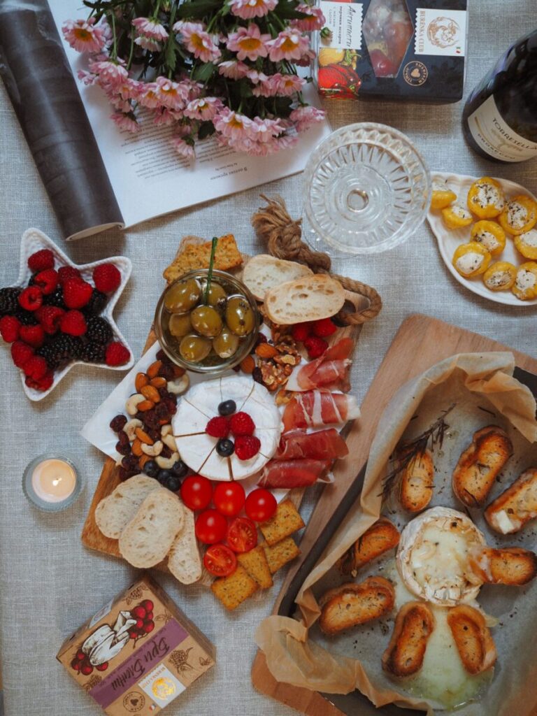 Delicious charcuterie spread featuring cheese, bread, and fruits in a cozy setting.