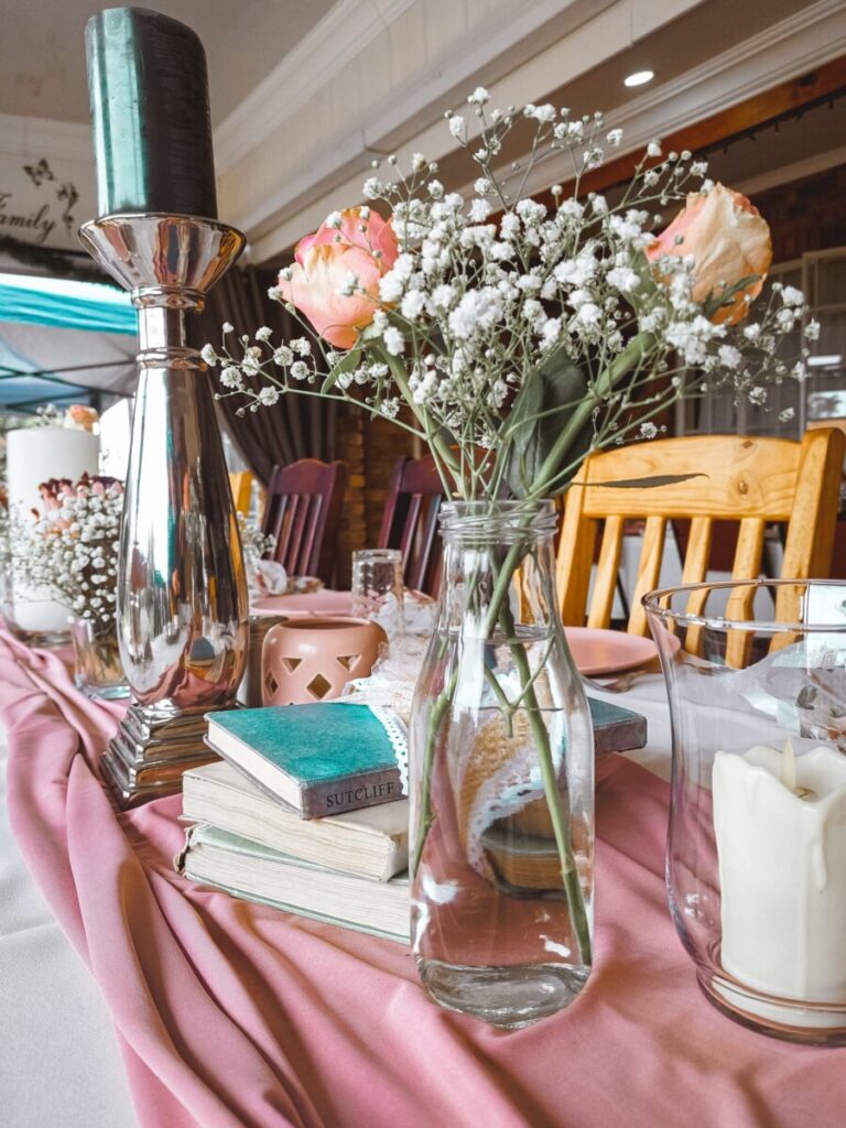 A chic table arrangement featuring flowers, books, and candles, perfect for an elegant event.